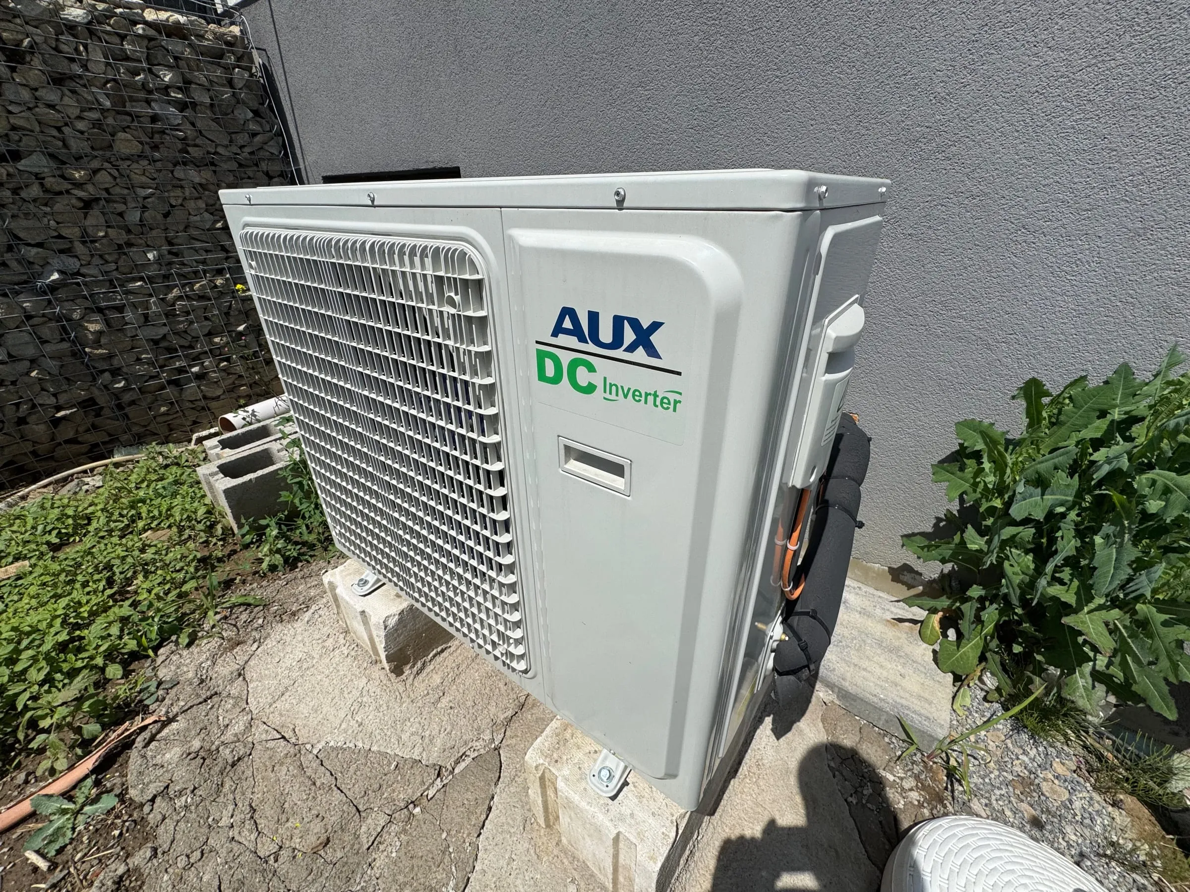 AUX DC Inverter vonkajšia jednotka osadená pri gabionovej stene