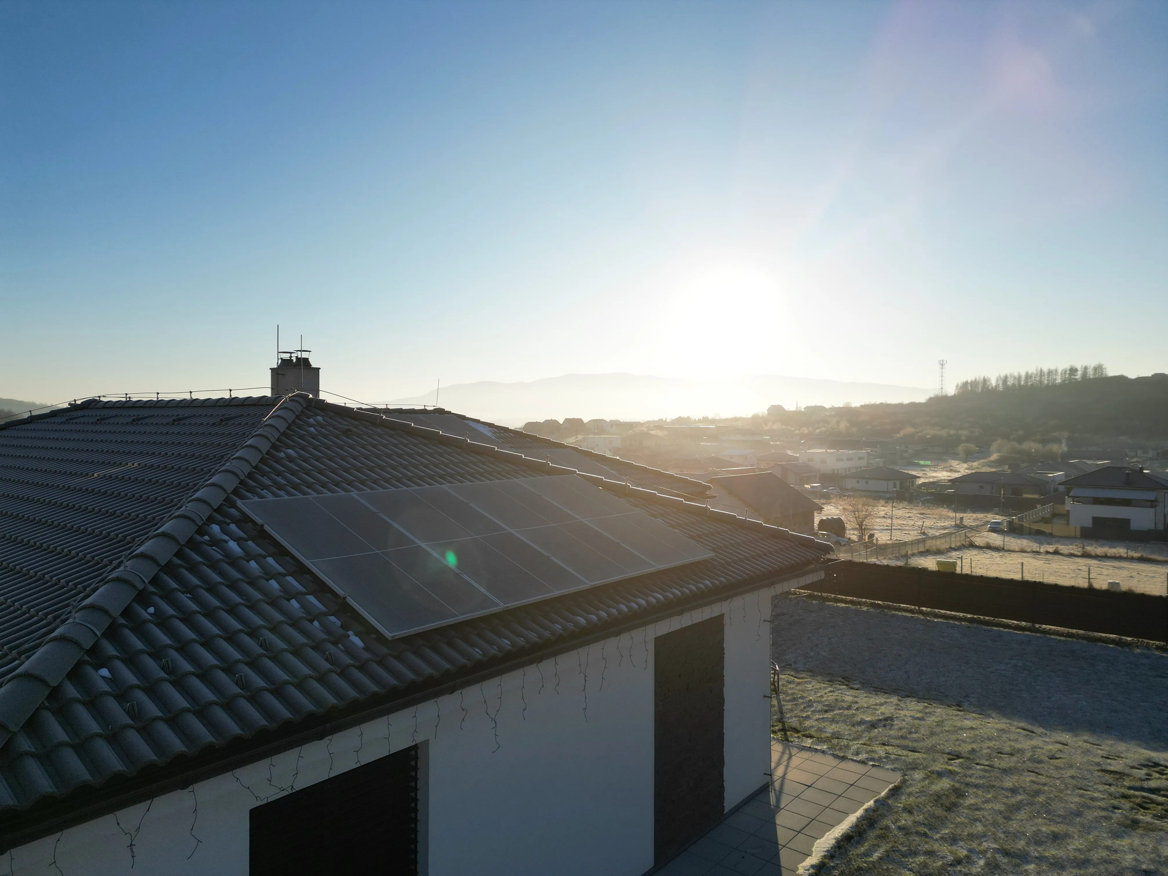 Rodinný dom s fotovoltickými panelmi pri zimnom východe slnka, realizácia Solár pre dom